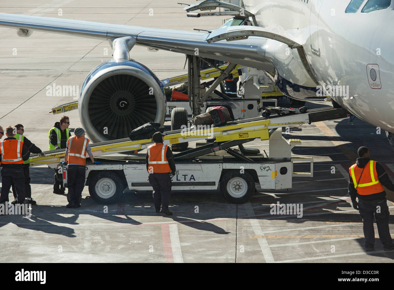 Denver, Colorado - das Bodenpersonal entlädt Gepäck vom Delta Airlines Flugzeug am Denver International Airport aus. Stockfoto