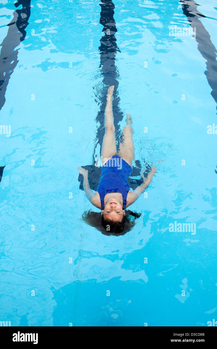 10 bis 11 Jahre altes Mädchen schwimmen Runden im Wettbewerb Stil Badeanzug. Stockfoto