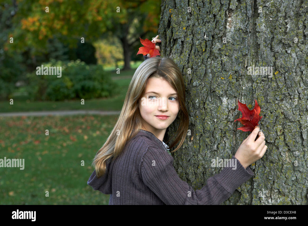 Schöne 7-jährige Mädchen halten bunte Herbstblatt. Stockfoto