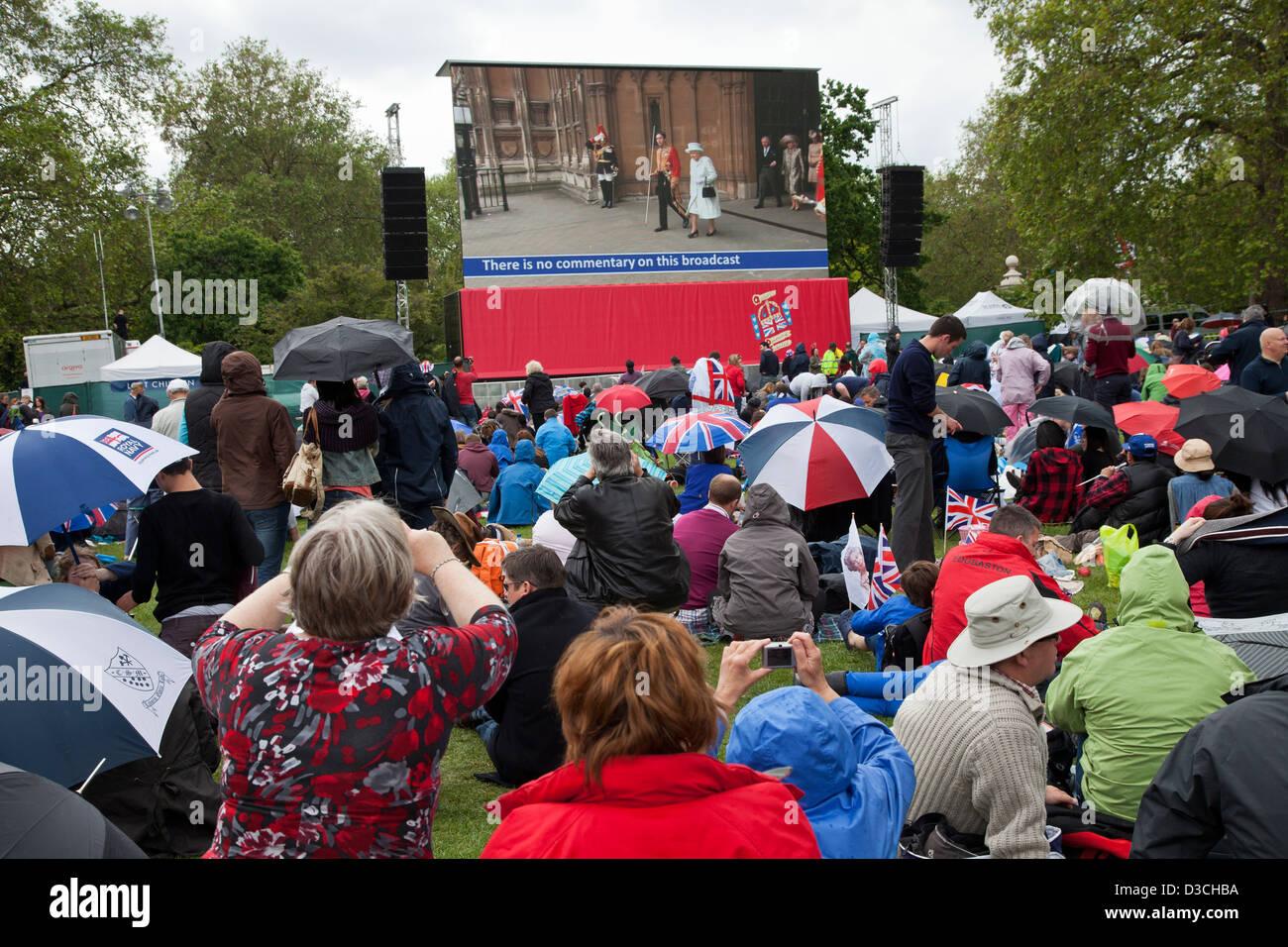 Menschen die Teilnahme an Diamanten Jubiläumsfeier in St James' Park beobachten der Königin Prozession auf outdoor Bildschirmen. Stockfoto