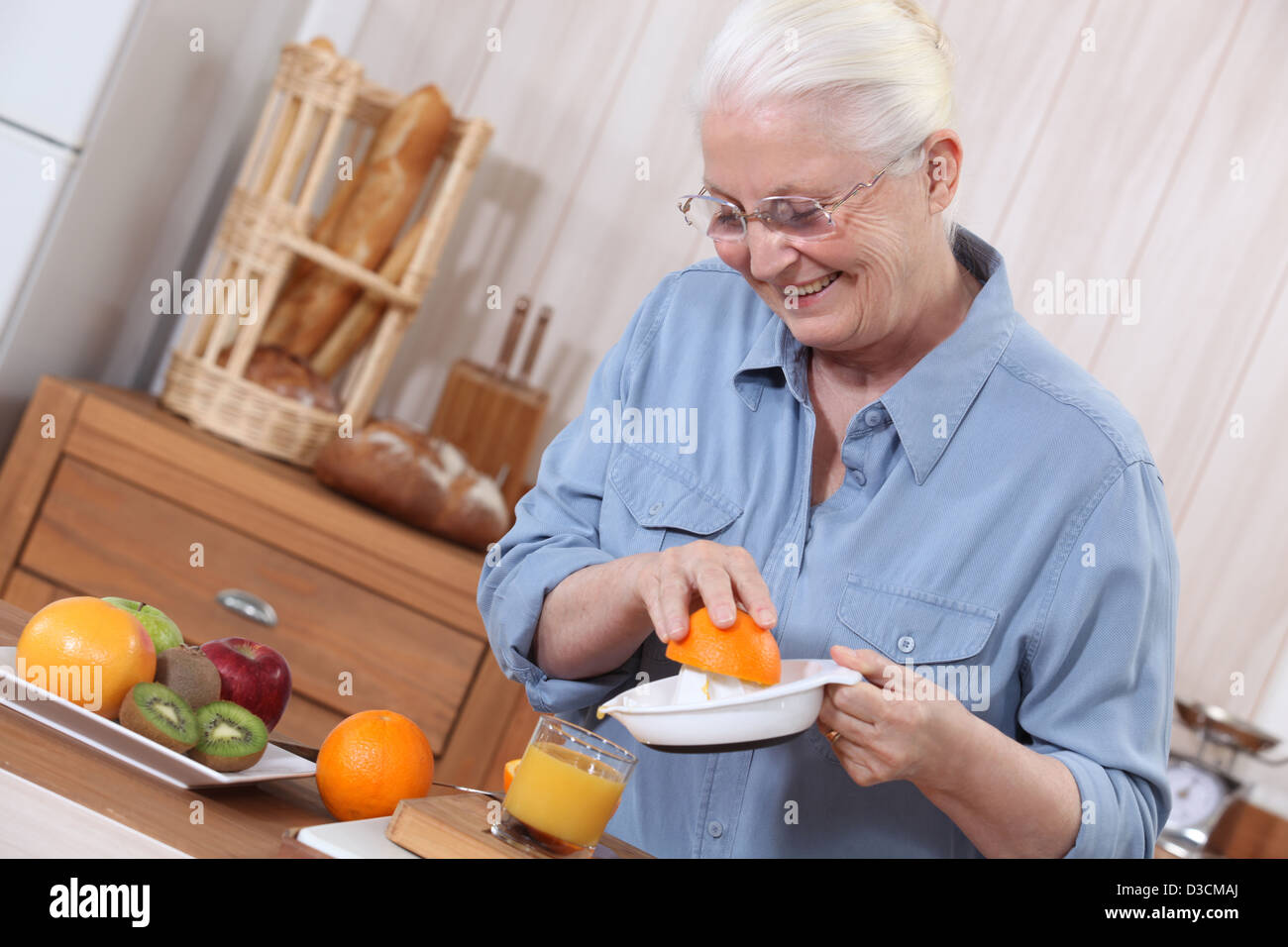 Ältere Dame drückte orange Saft Stockfoto