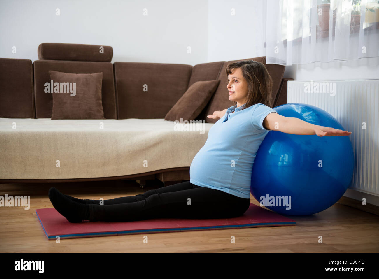Schwangere Frau mit Fit Ball zu Hause trainieren Stockfoto
