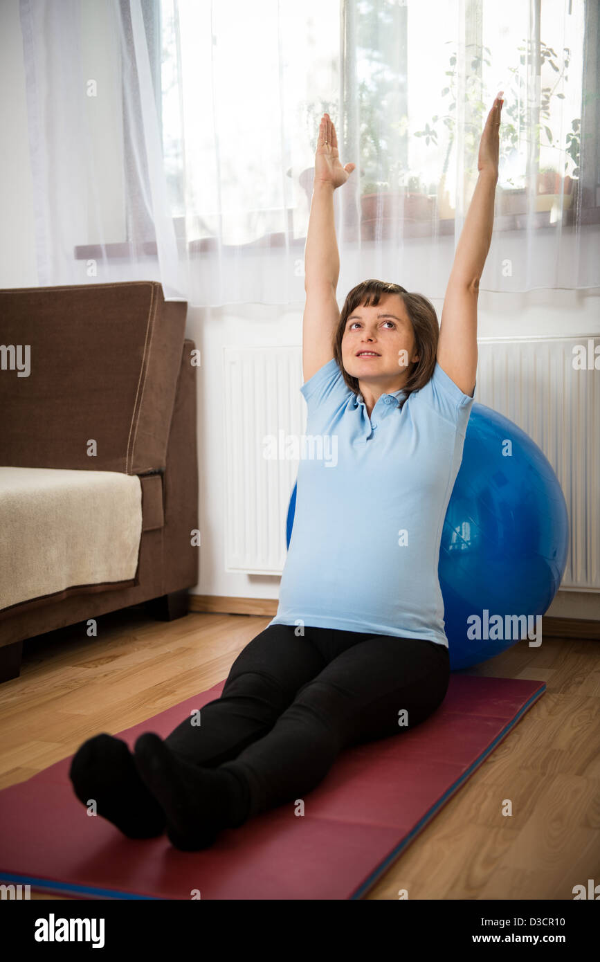 Schwangere Frau mit Fit Ball zu Hause trainieren Stockfoto