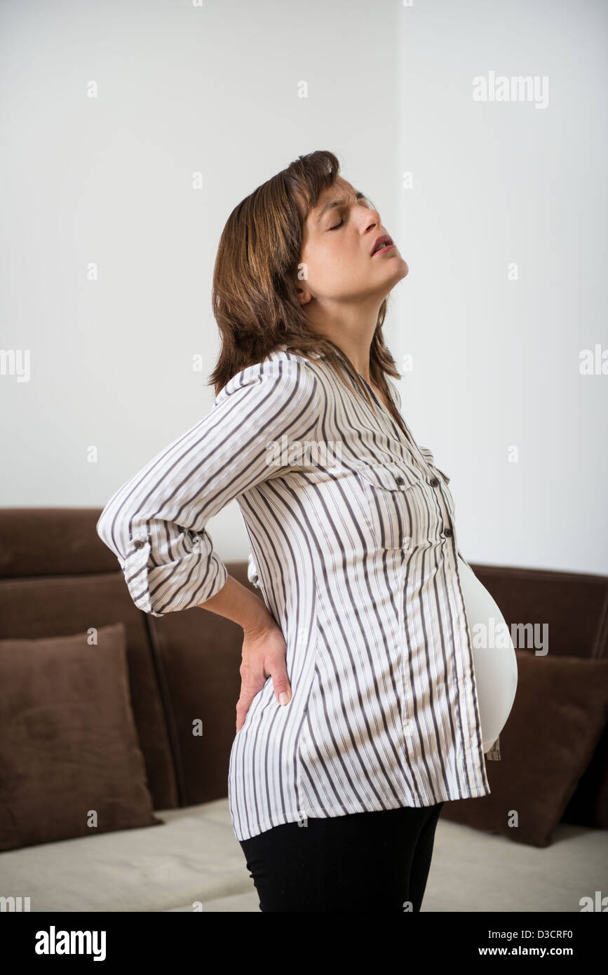 Schwangere Frau sitzen auf Fit Ball mit Rückenschmerzen Stockfoto