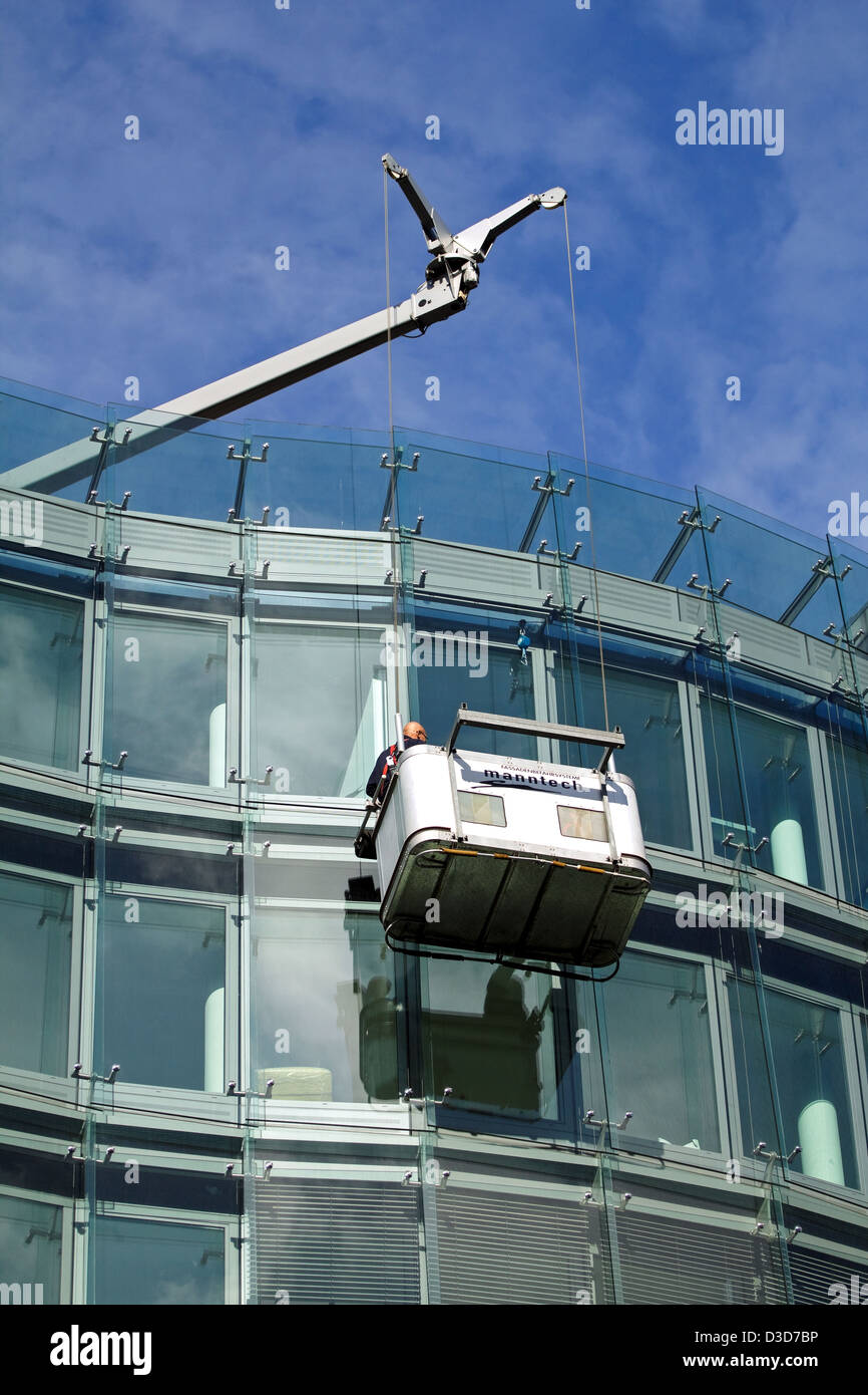 Berlin, Deutschland, Glaser kontrollieren die Fenster eines Gebäudes nach außen Stockfoto