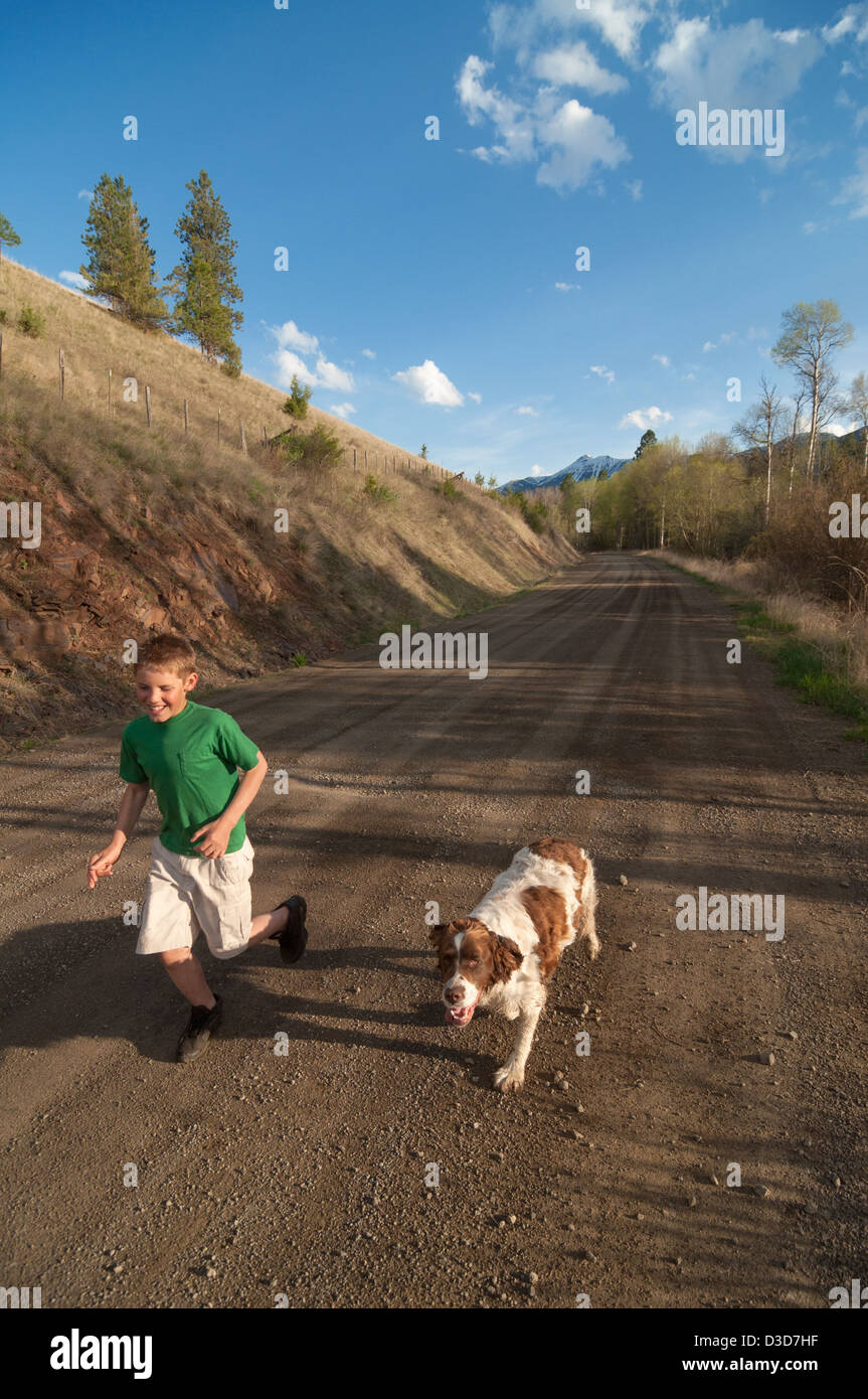 Junge mit Hund auf der Landstraße in Oregon Wallowa Valley ausgeführt. Stockfoto