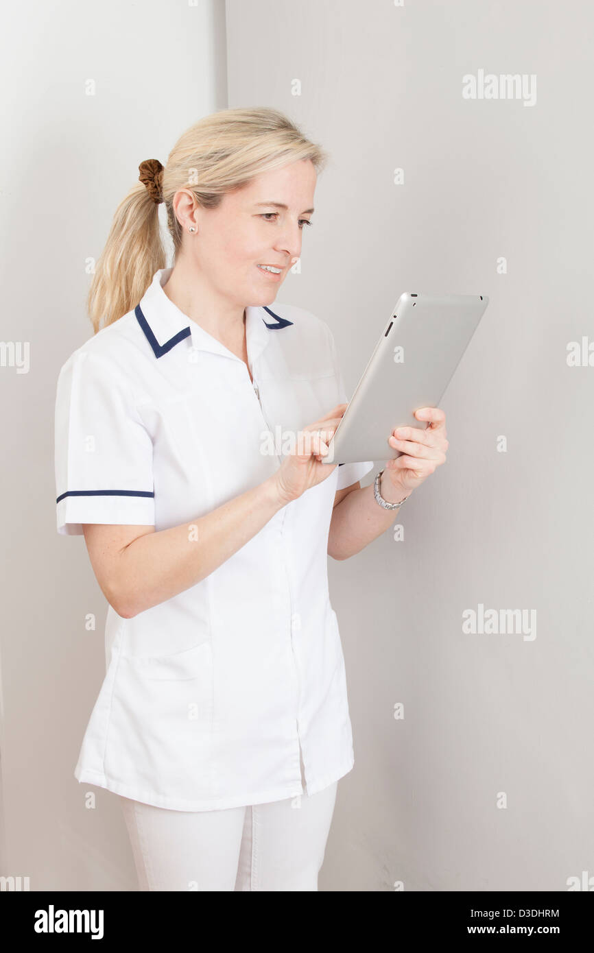 Blonde Krankenschwester (Zahn-) mit einem digitalen Tablet. Stockfoto