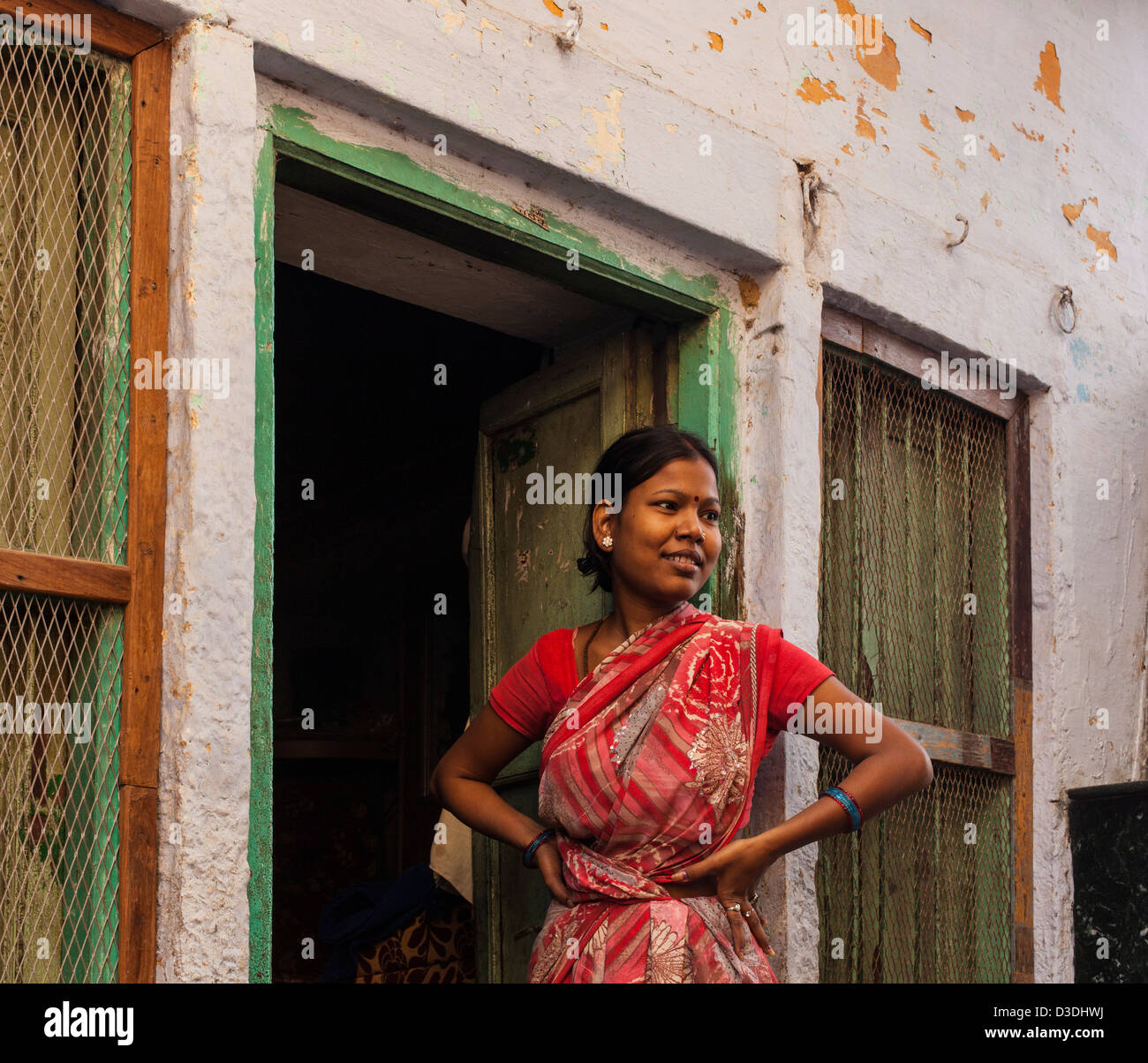 Indische Frau, die in einem Hauseingang, Varanasi, Indien Stockfoto