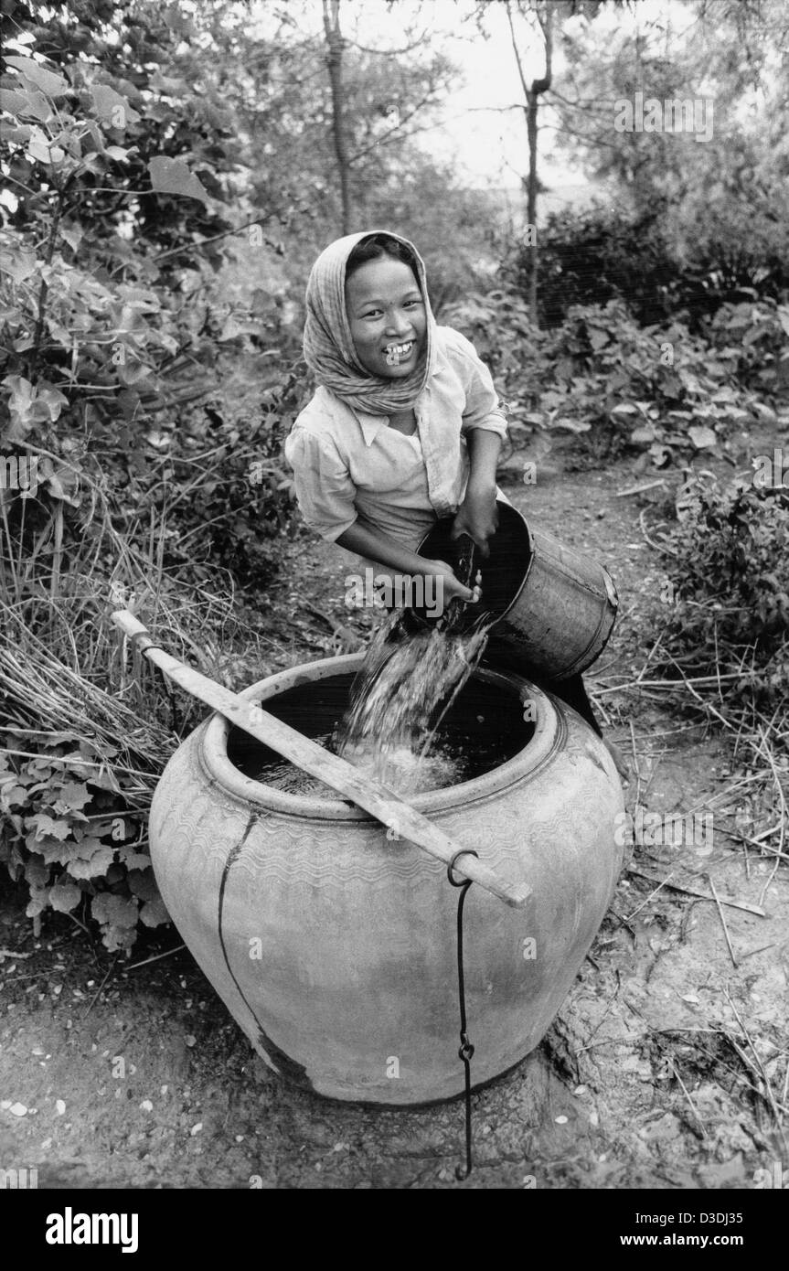 Prey Veng Provinz, Kambodscha: eine junge Frau den Haushalt Glas Wasser füllt sich mit Wasser aus einem Brunnen. Stockfoto