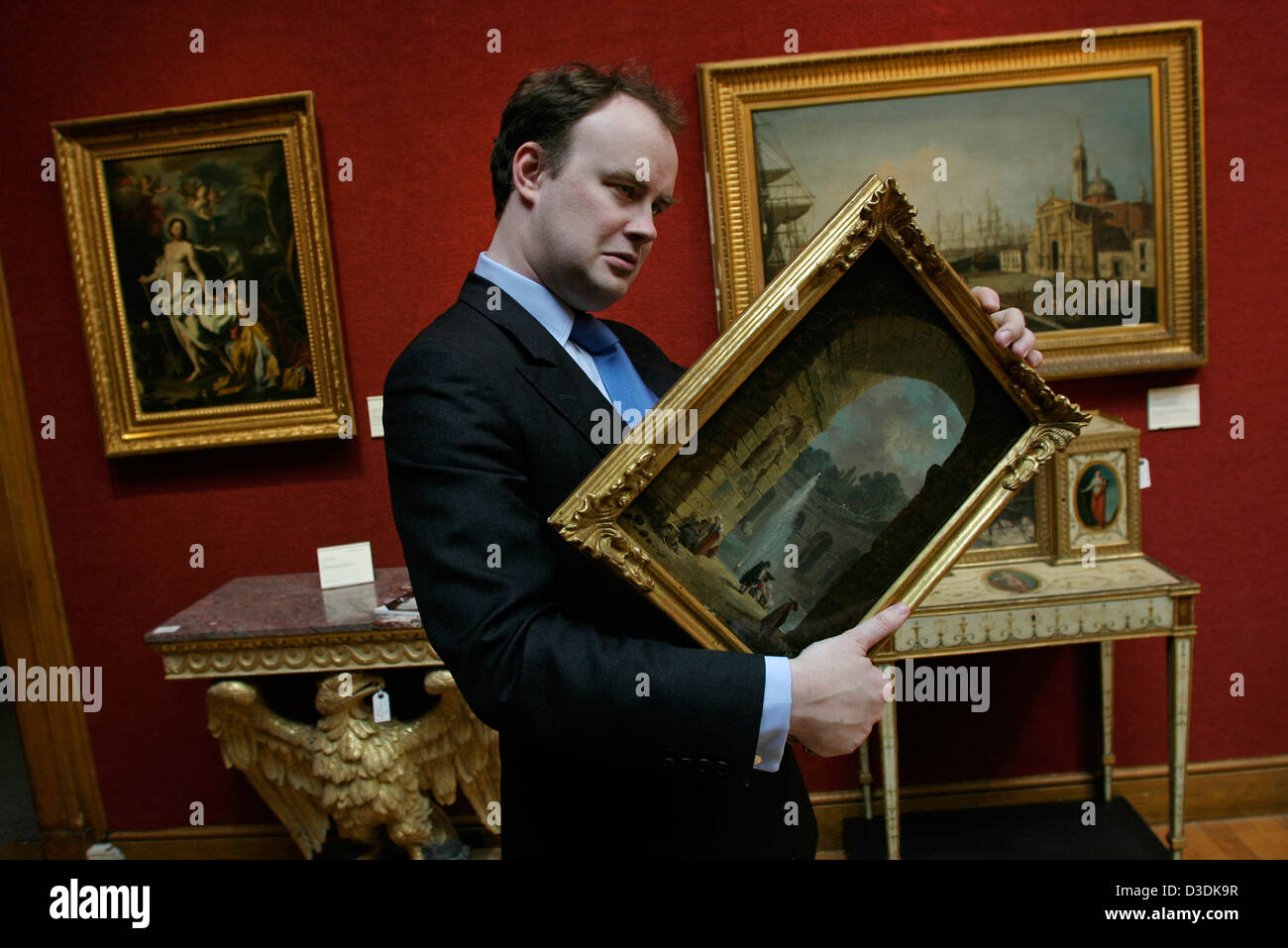 LONDON, ENGLAND - März 2004: Christie Kunstexpertin Alex Hope untersucht "Eine zerstörte Galerie mit Hirten durch einen Brunnen" von Hubert Robert Stockfoto