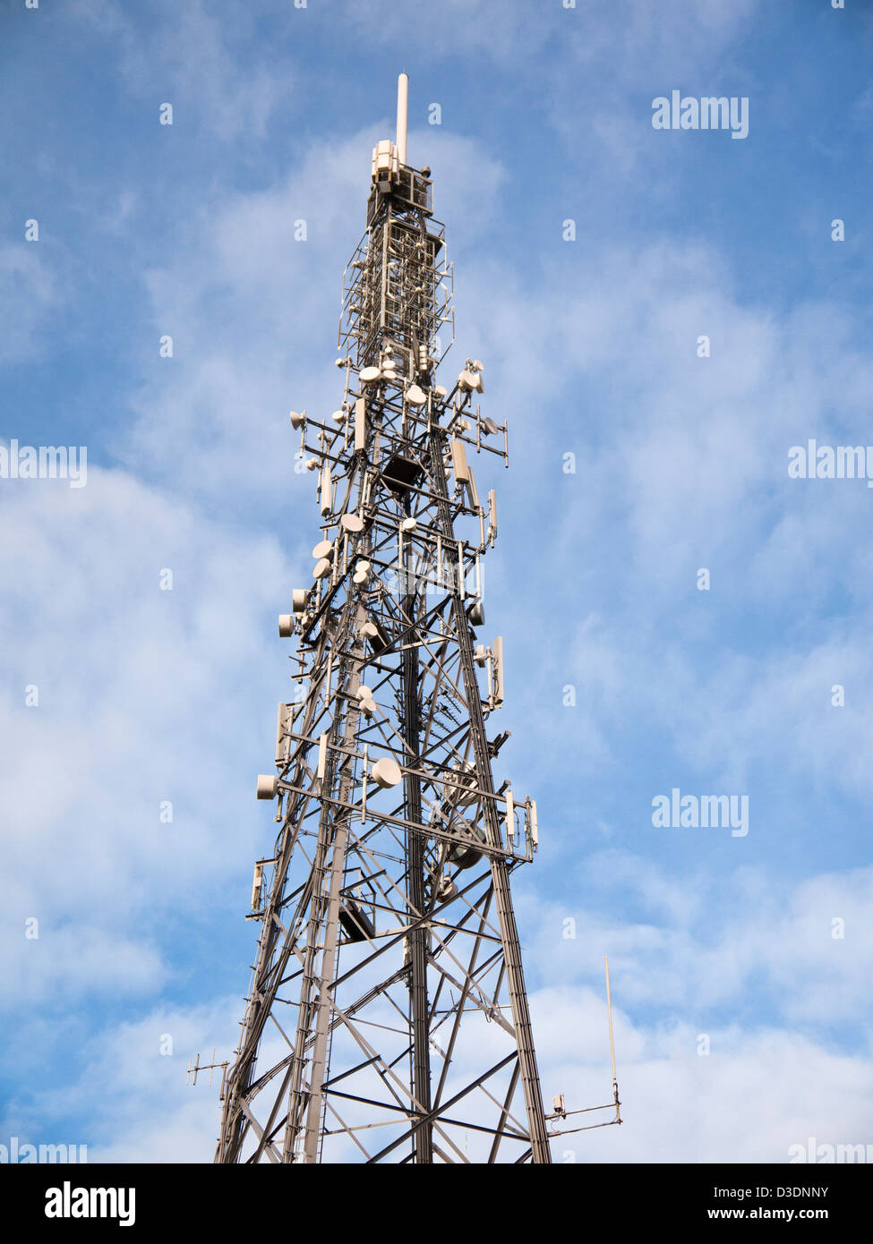 Communications Tower mit vielen Antennen und Gerichte vor blauem Himmel Stockfoto