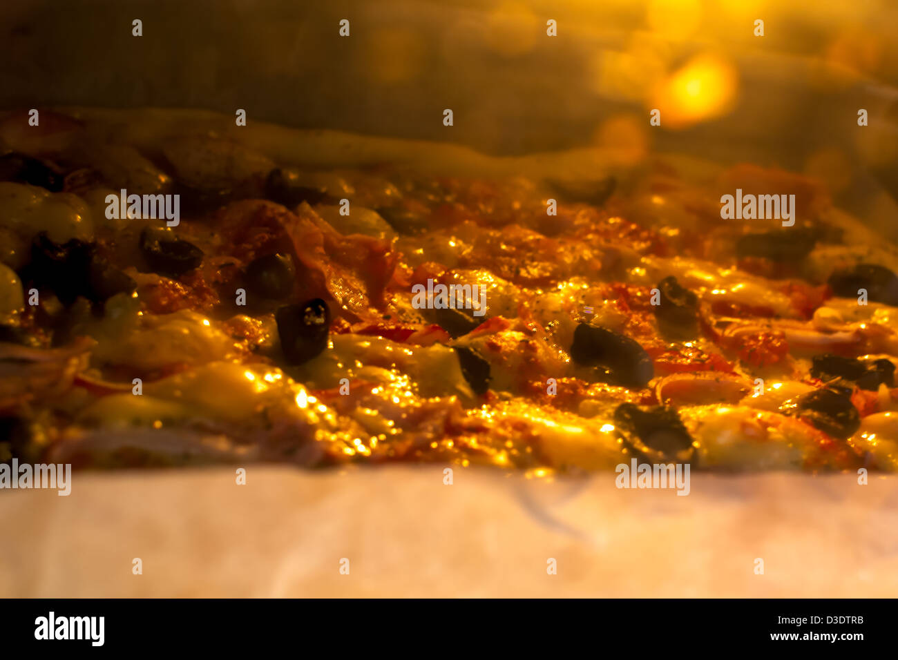 Pizza mit Schinken, Oliven, Zwiebeln und Tomatensoße Backen im Ofen angeordnet. Stockfoto