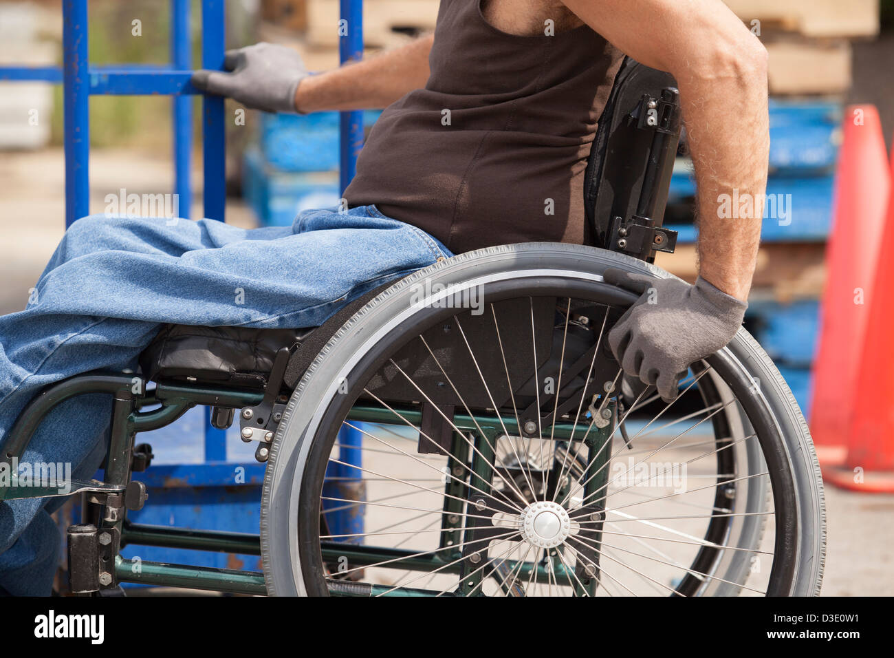 Laden Hafenarbeiter mit Querschnittslähmung im Rollstuhl bewegen einen Hand-LKW Stockfoto