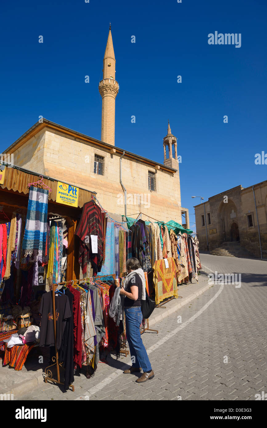 Weibliche Touristen shopping für Kleidung in Mustafapasa Dorf mit Minarett und Universität Berufsschule in Cappadocia Türkei Stockfoto