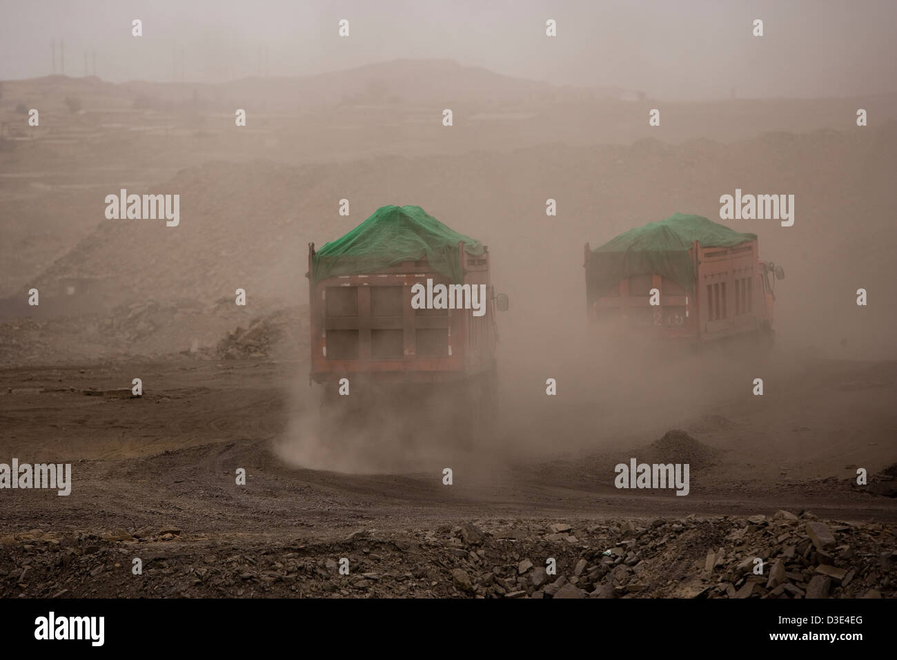 WUDA COAL FIELD, WU HAI, Innere Mongolei, CHINA - AUGUST 2007: Wolken von Staub füllen die Luft von Lastwagen mit Kohle aus öffnen Besetzung Minen Stockfoto