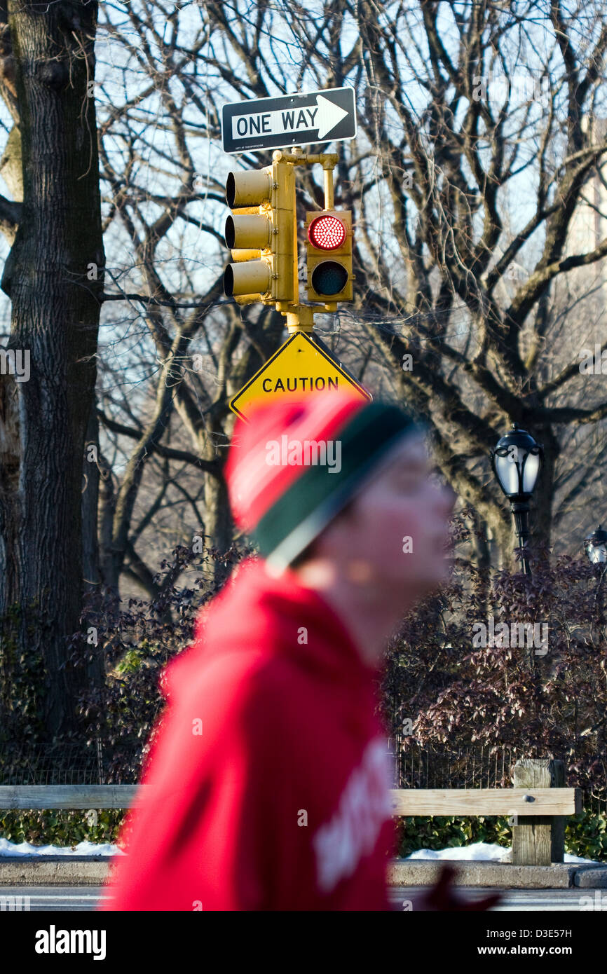 Von Fokus Läufer Joggen Vergangenheit abmelden "One Way" an der Spitze einer Verkehrsampel im New Yorker Central Park Stockfoto