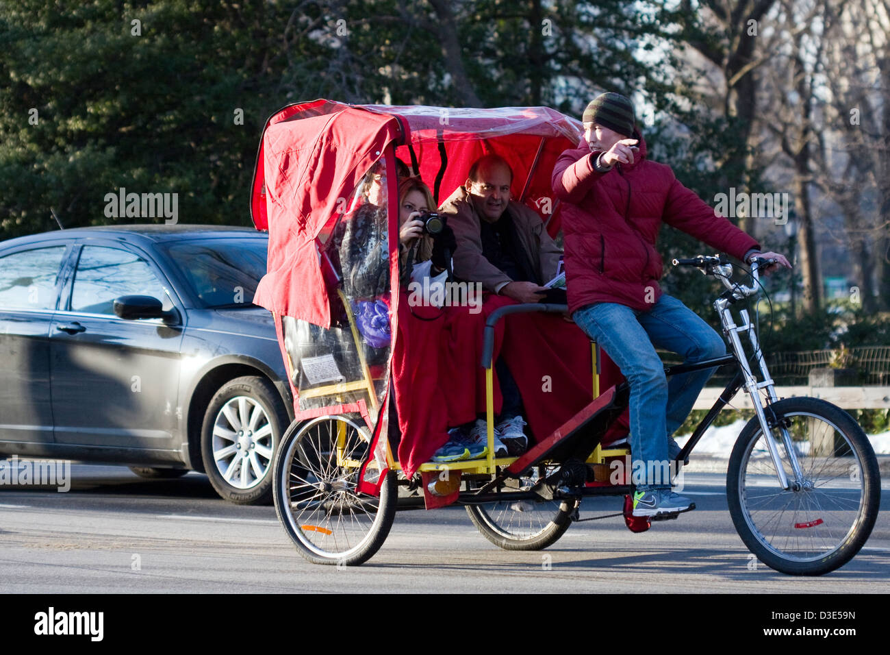 Rikscha-Fahrer weist darauf hin, interessante Sehenswürdigkeiten, wie ein Tourist ihre Kamera zu fotografieren Central Park in New York City bereitet. Stockfoto