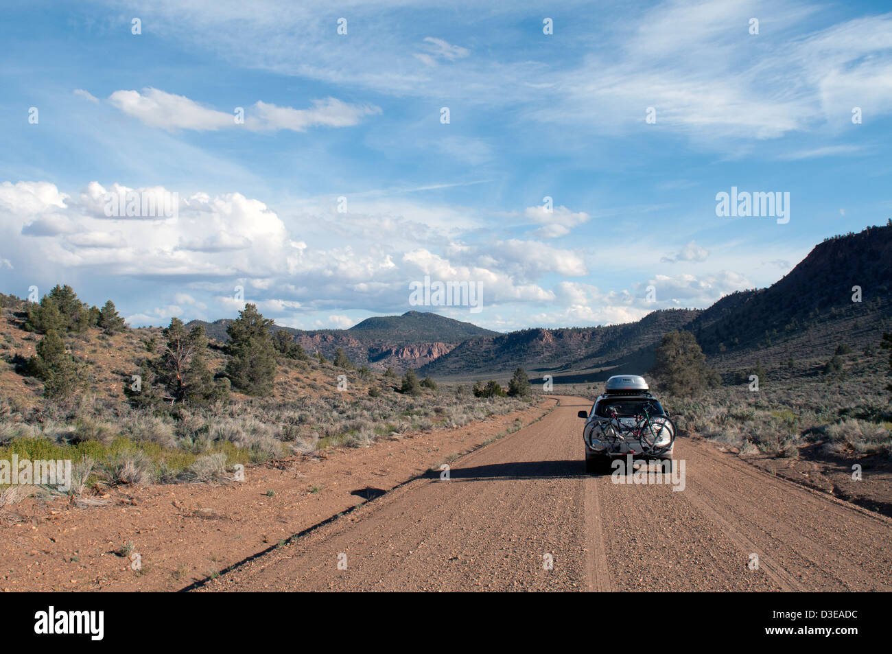 4WD Auto fährt auf einer unbefestigten Straße auf einem Roadtrip durch Owens Valley, Kalifornien in der Nähe von Bischof auf dem Weg zum Red Canyon bei Sonnenuntergang. Stockfoto