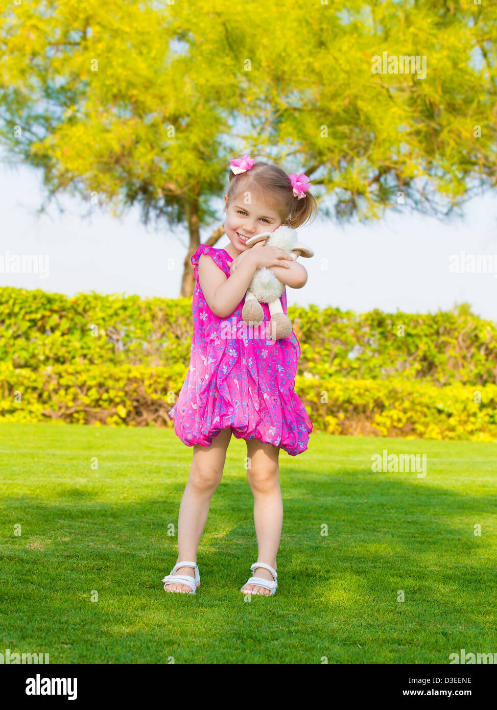 Foto der niedliche kleine Mädchen hält in Händen Stofftier, süßes Baby draußen spielen, entzückende kleine Weibchen haben Spaß im Hinterhof Stockfoto