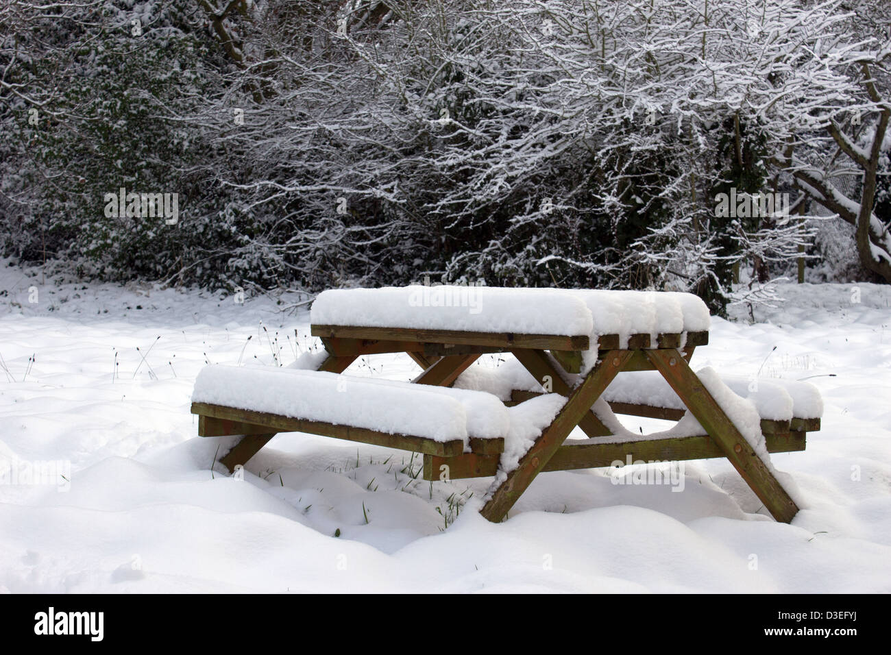 Schneebedeckte Picknickbank im Garten Stockfoto