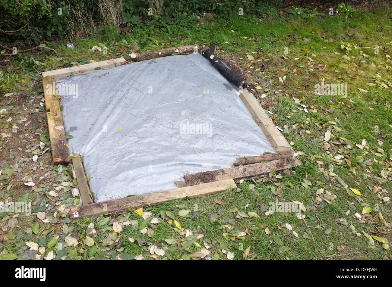 Boden mit Kunststoff zum Aufwärmen der Erde für den Anbau von Gemüse bedeckt Stockfoto