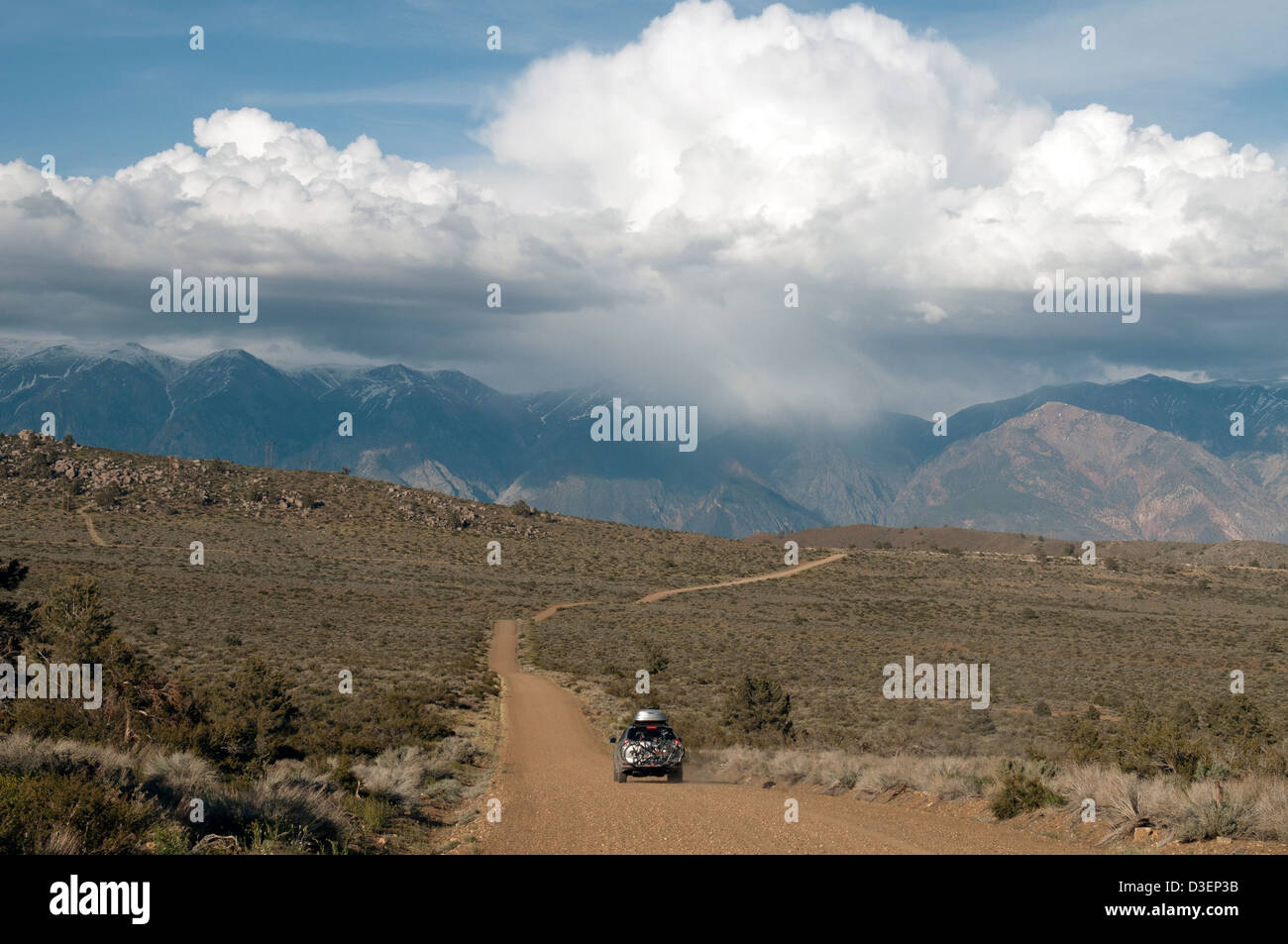 4WD Auto fährt auf einer unbefestigten Straße auf einem Roadtrip durch Owens Valley, Kalifornien in der Nähe von Bischof auf dem Weg zum Red Canyon bei Sonnenuntergang. Stockfoto