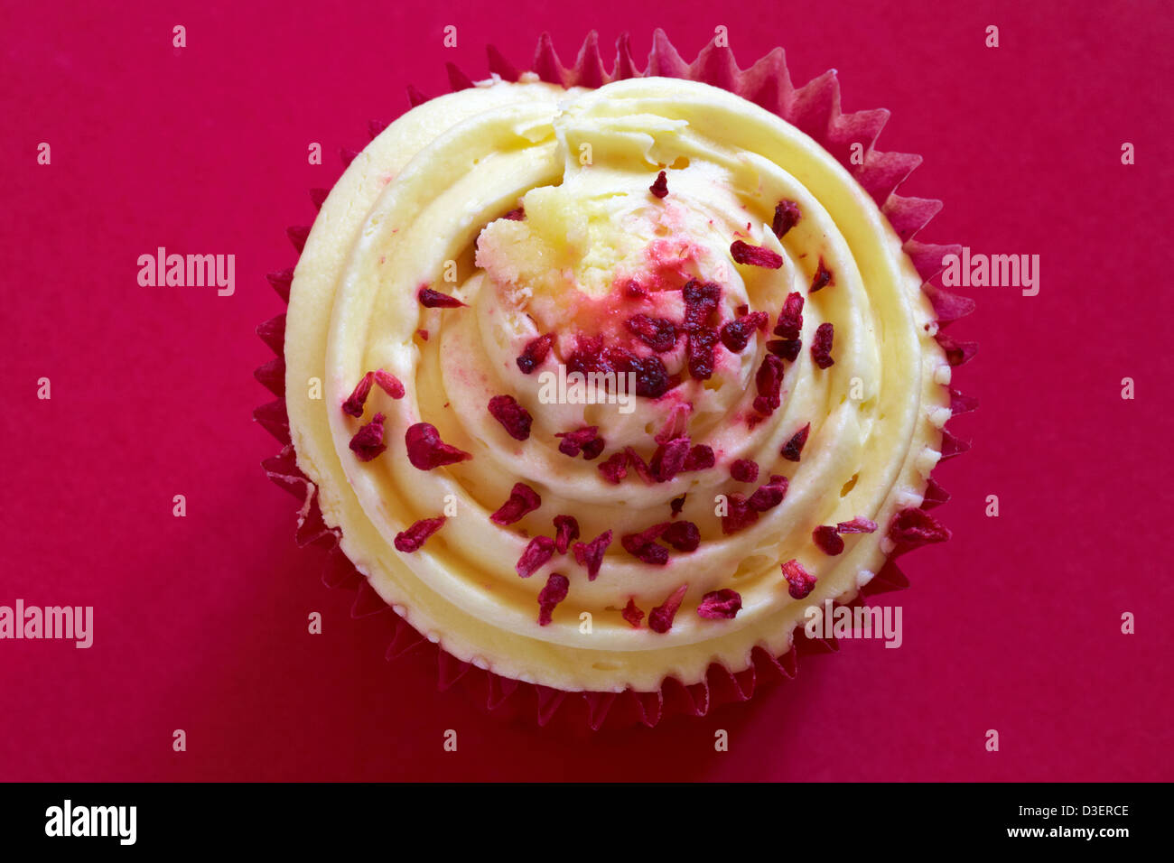 Tesco Finest leidenschaftliche Himbeer Cupcake isoliert auf rotem Grund Stockfoto