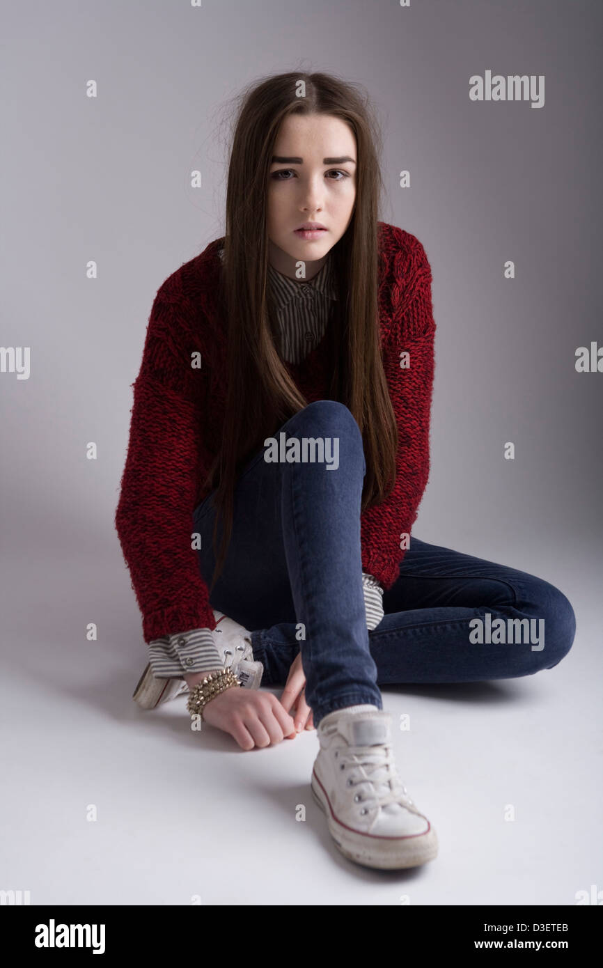 Porträt eines 15-jährigen Mädchens sitzen auf einem Studioboden. Stockfoto