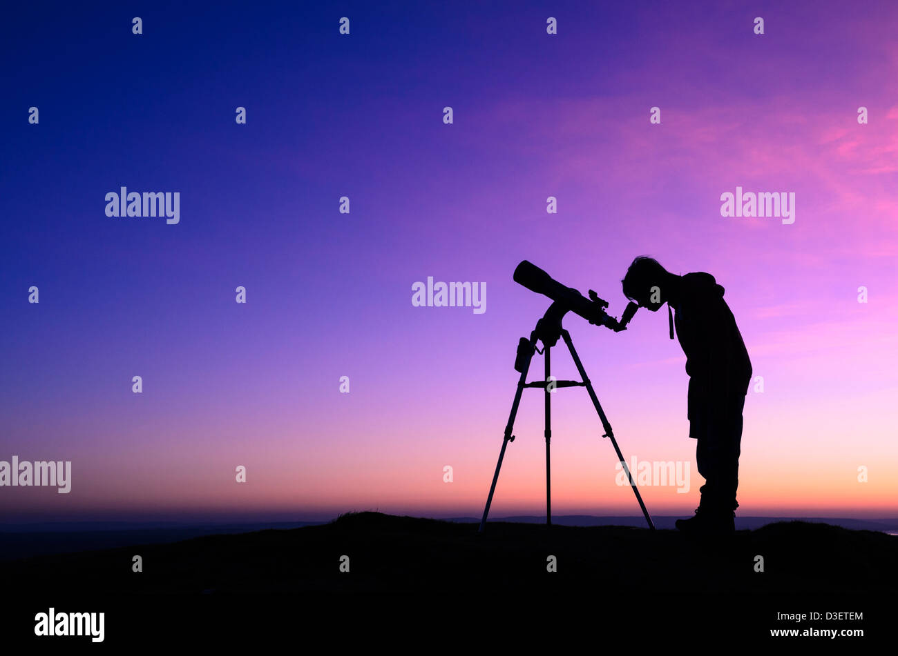 Die Silhouette von einem Teenager Sternenhimmel mit einem Teleskop in der Abenddämmerung Stockfoto