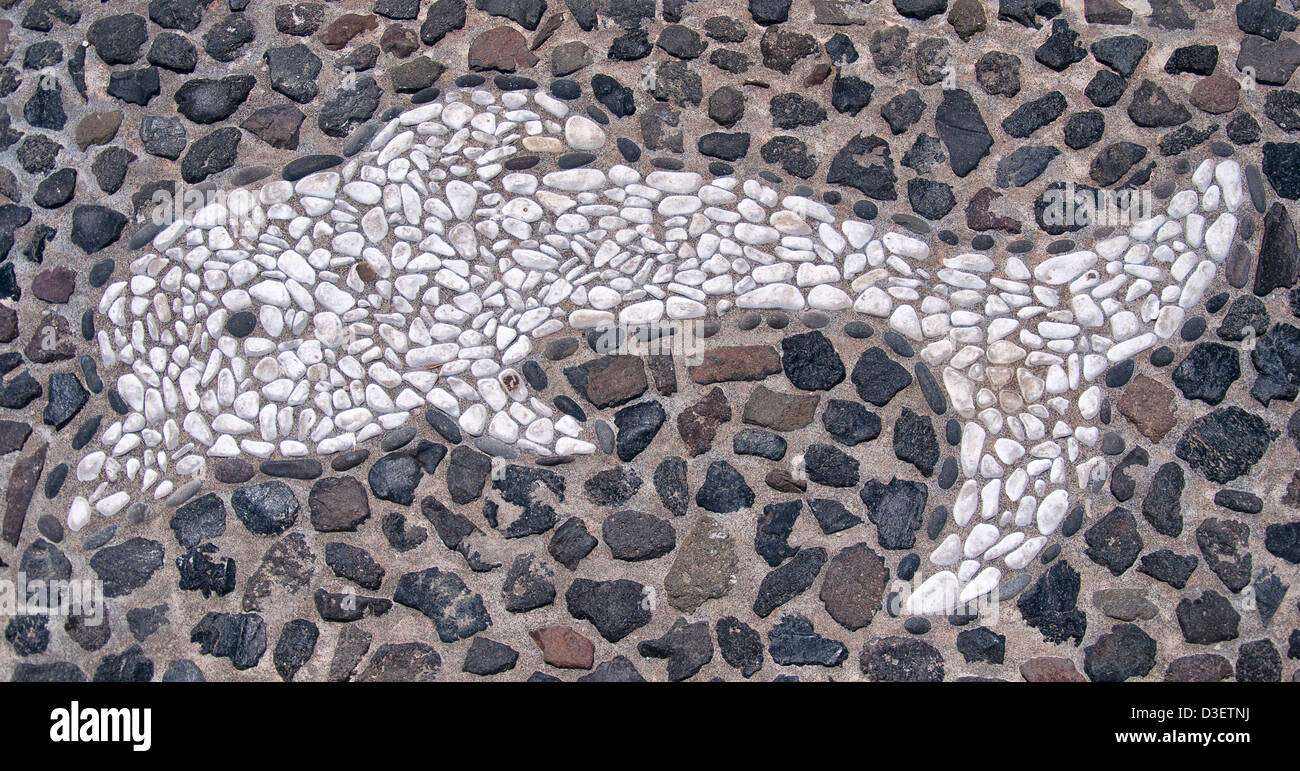 Ein Mosaik aus einer Flasche Nase Delphin bestehend aus weißen Kieselsteinen auf dem Boden befindet sich auf der griechischen Insel Santorin. Stockfoto