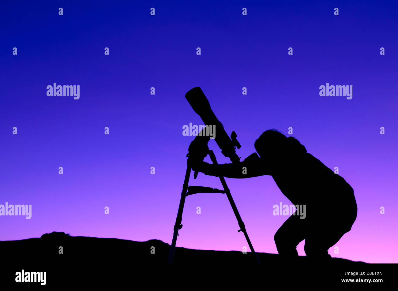 Die Silhouette einer Frau in der Dämmerung mit einem Teleskop Sternenhimmel Stockfoto