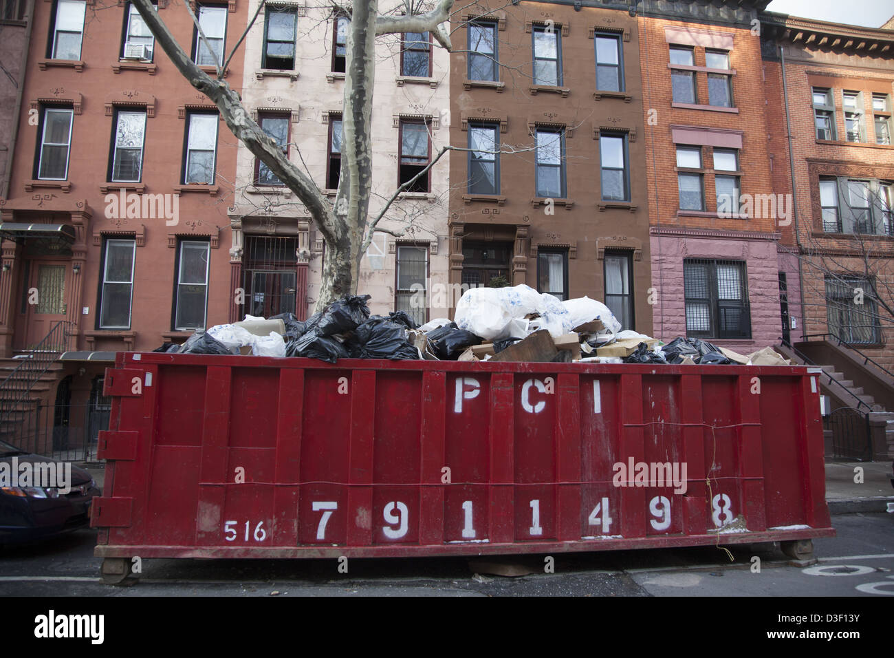 Müllcontainer vor einem Mehrfamilienhaus bei Renovierung in Crown Heights, Brooklyn, NY. Stockfoto