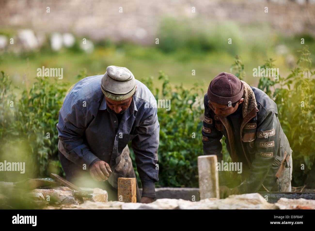 Zwei Männer arbeiten auf ein Bewässerungssystem im Ortsbild Ruinen Baalbek im Libanon Beqaa Tal. Stockfoto
