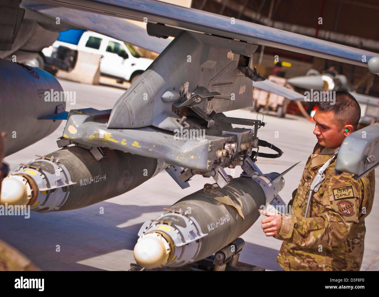Ein US Air Force-Pilot inspiziert eine GBU-38-Bombe auf ein Kampfflugzeug geladen 11. Februar 2013 am Kandahar Flugplatz, Afghanistan. Stockfoto