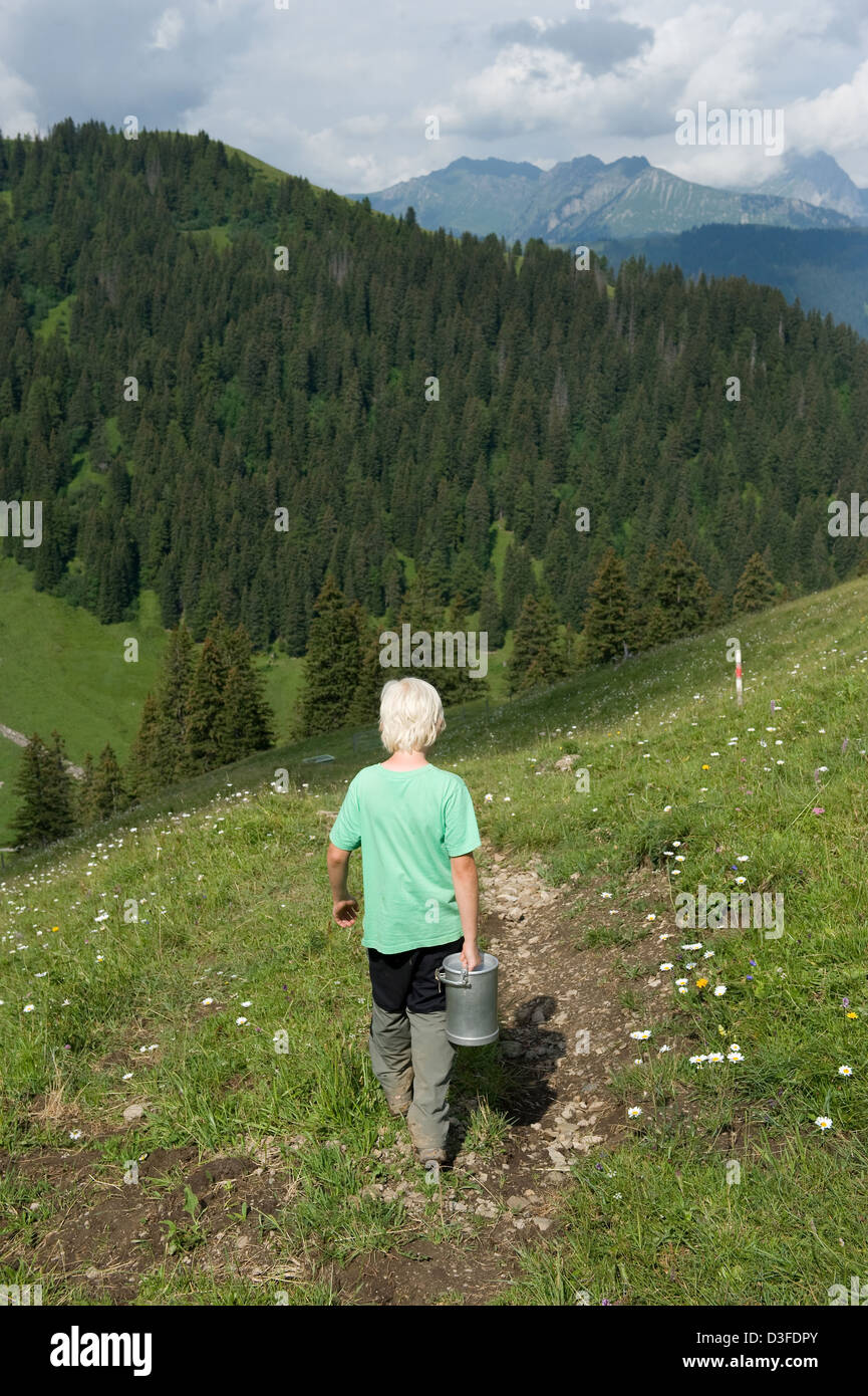 Blatti Alm in der Schweiz geht ein Junge, Milch zu erhalten Stockfoto