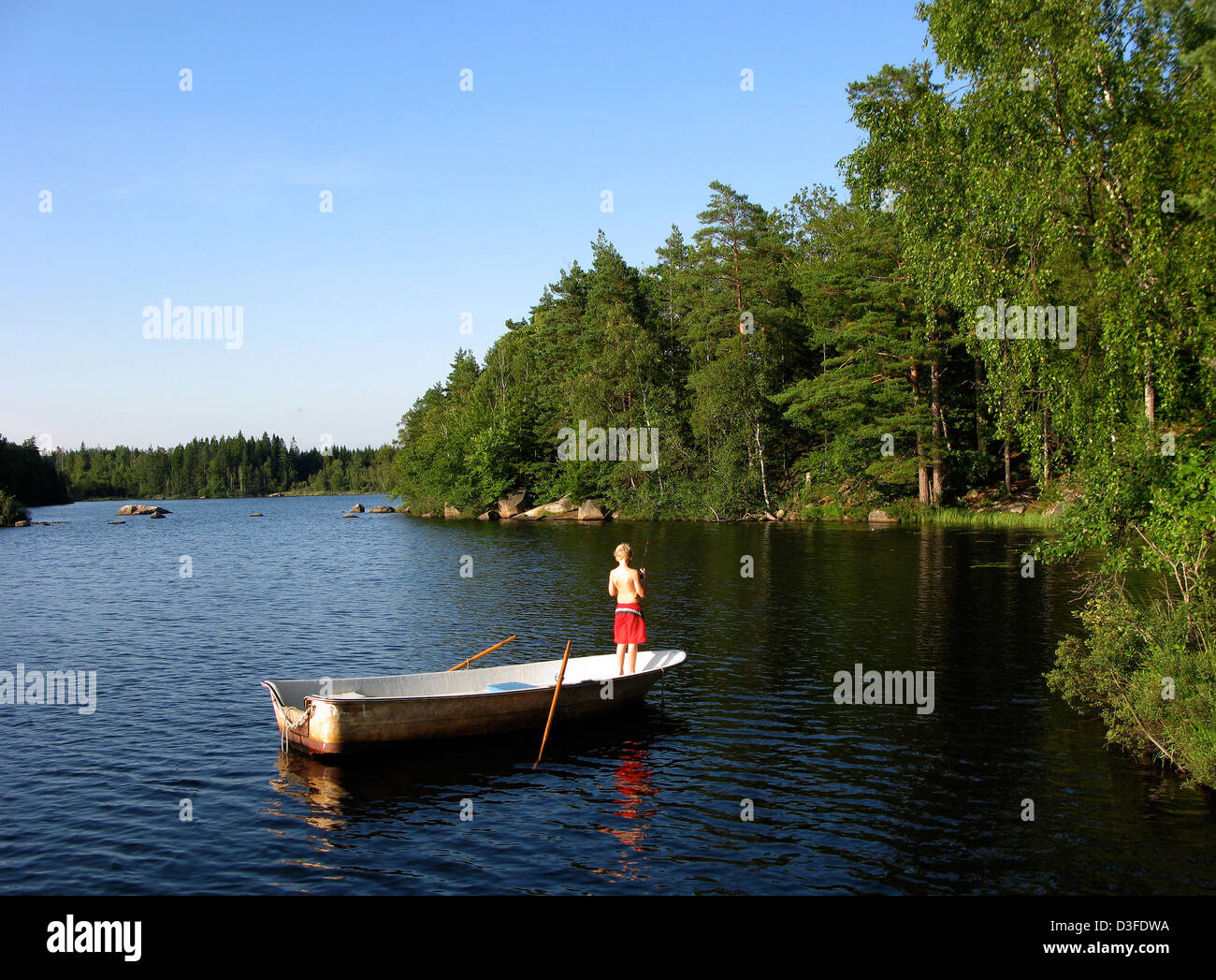 Karlskrona, Schweden, ist ein Kind in einem Ruderboot und Angeln Stockfoto