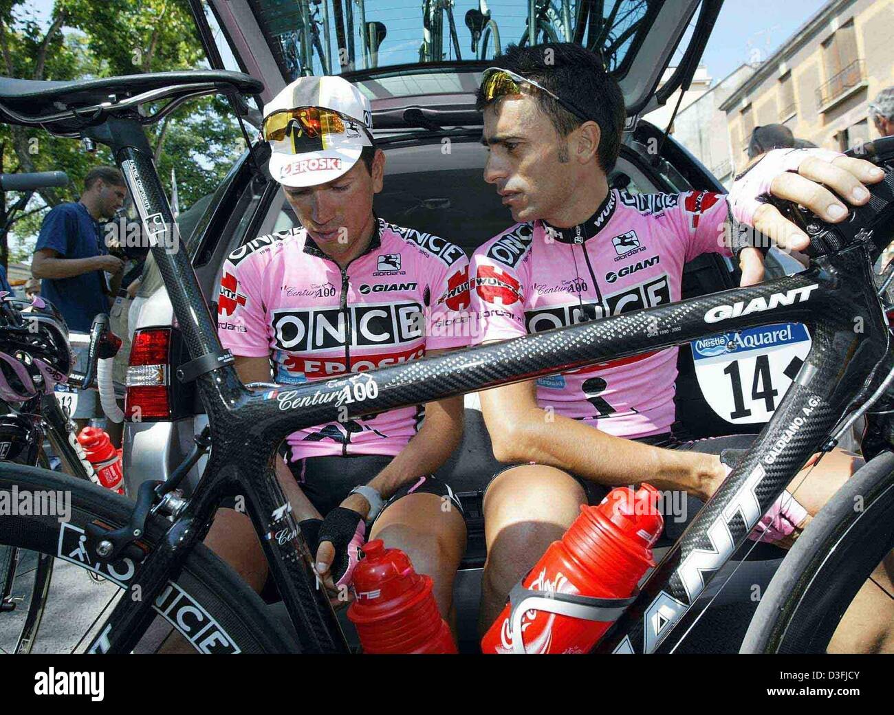 (Dpa) - spanische Radfahrer Alvaro Gonzalez de Galdeano (R) und Spanisch Radfahrer Jose Azevedo (Team einmal-Eroski) sitzen auf der Rückseite eines Autos und Aussehen schockiert vor dem Start der 10. Etappe der Tour de France in Gap, Frankreich, 15. Juli 2003. Ihre Teamkapitän Joseba Beloki (Team einmal-Eroski), die den zweiten in der Gesamtwertung Platz hatte einen schweren Unfall, in dem er einen Bro zugezogen Stockfoto