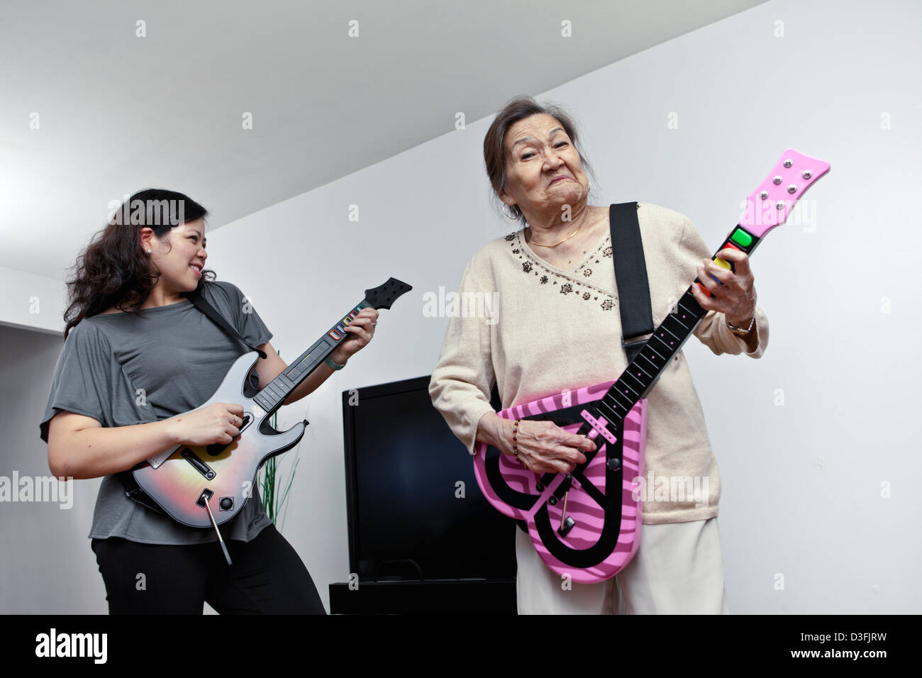 Asiatische Frauen zwei Generationen in der Familie Spaß Gitarre elektronisches Spiel Stockfoto