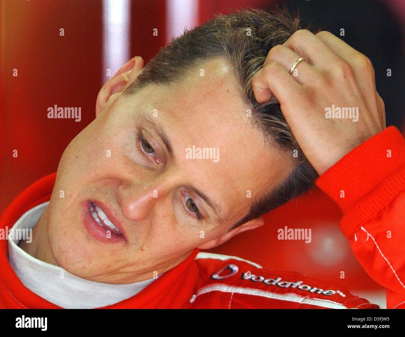 (Dpa) - deutscher Formel-1-Fahrer Michael Schumacher (Ferrari) kratzt sich am Kopf während des freien Trainings für den französischen Grand Prix auf der Rennstrecke verfolgen in Magny-Cours, Frankreich, 5. Juli 2003. Michael Schumacher gewann den dritten Platz im Rennen am 6. Juli. Stockfoto