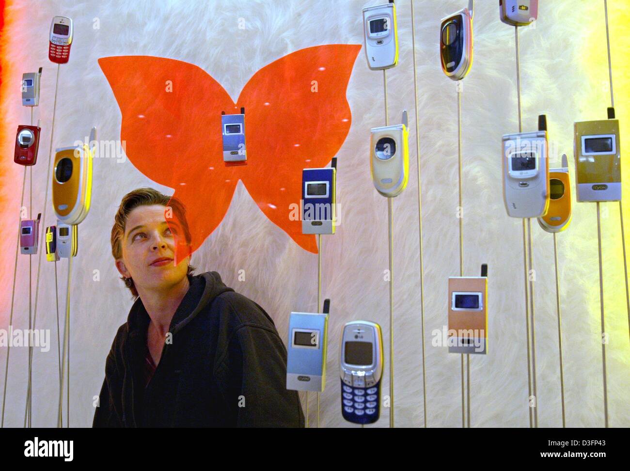 (Dpa) - ein Mitarbeiter von LG Electronics schaut die Mobiltelefone auf Sticks für die Anzeige am Stand des Unternehmens Markt fest, ein Tag im Voraus von der Eröffnung der weltweit größten Computer Handel Messe CeBIT in Hannover, Deutschland, 11. März 2003. Die CeBIT wird voraussichtlich vom 12. bis 19. März 2003 stattfinden. Sollen mehr als 6.500 Unternehmen aus der ganzen Welt präsentieren ihre Produkte, whi Stockfoto