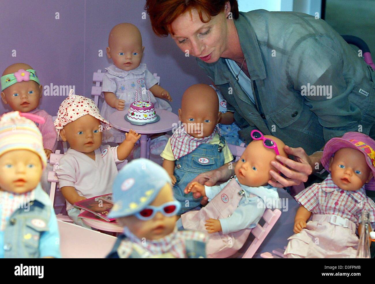 Dpa) - Angelika Marr, Designer und Produktentwickler bei Zapf Creation,  Hersteller von Spielzeug und Puppen, schmückt eine Gruppe von "Baby born"  Puppen in Roedental, Deutschland, 6. Mai 2003. Die "Baby born" Puppen