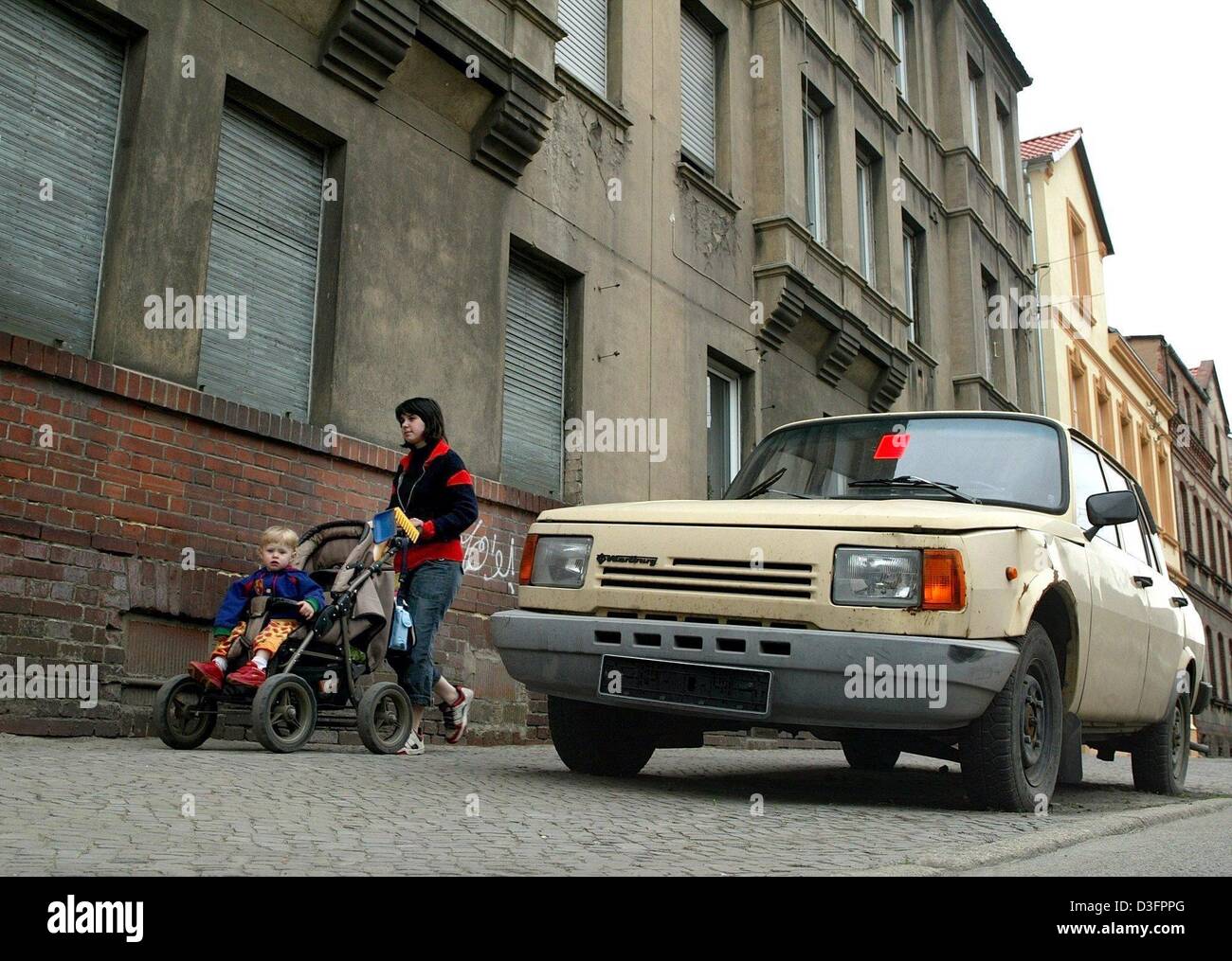 (Dpa) - eine Frau mit einem Buggy geht ein "Wartburg" Auto in Stendal, Ostdeutschland, 6. Mai 2003. "Wartburg" wurde in der ehemaligen DDR (Deutsche Demokratische Republik) produziert. Nördlichen Sachsen-Anhalt ist nach wie vor sehr schlecht strukturiert und hat eine Arbeitslosenquote von 21 Prozent. Stockfoto