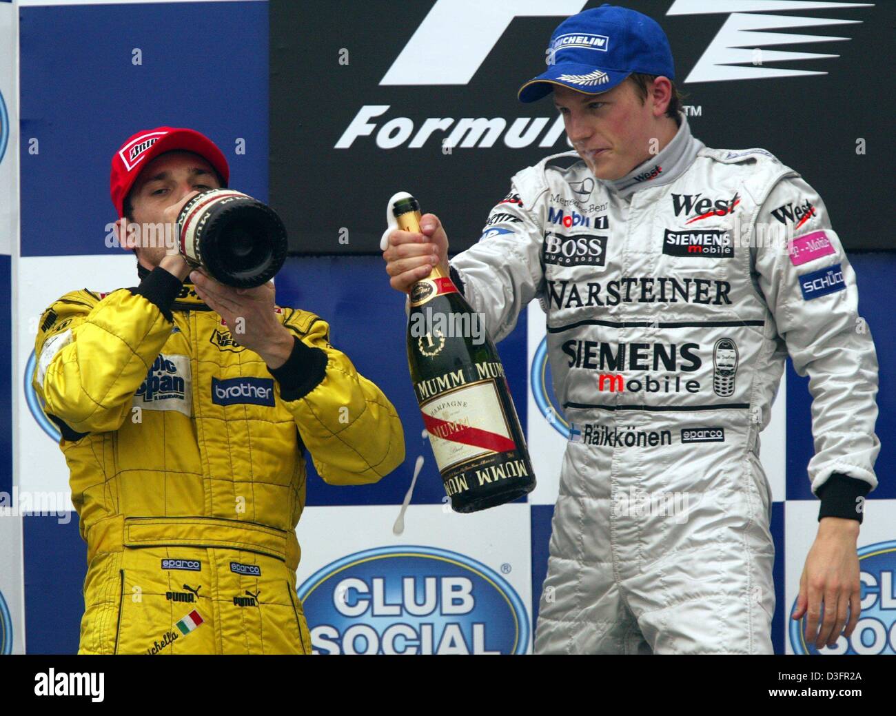 (Dpa) - Formel 1-Piloten Kimi Raeikkoenen (R) aus Finnland (Team McLaren-Mercedes) und Giancarlo Fisichella (Jordan-Team) Italien Drink Flaschen Champagner nach dem Gewinn des Grand Prix von Brasilien auf der Rennstrecke von Interlagos in Sao Paulo, Brasilien, 6. April 2003. Dann wurde Raeikkoenen den Gewinner des Grand Prix von Brasilien erklärt, nachdem das Rennen in Runde 55 wegen der gestoppt wurde Stockfoto