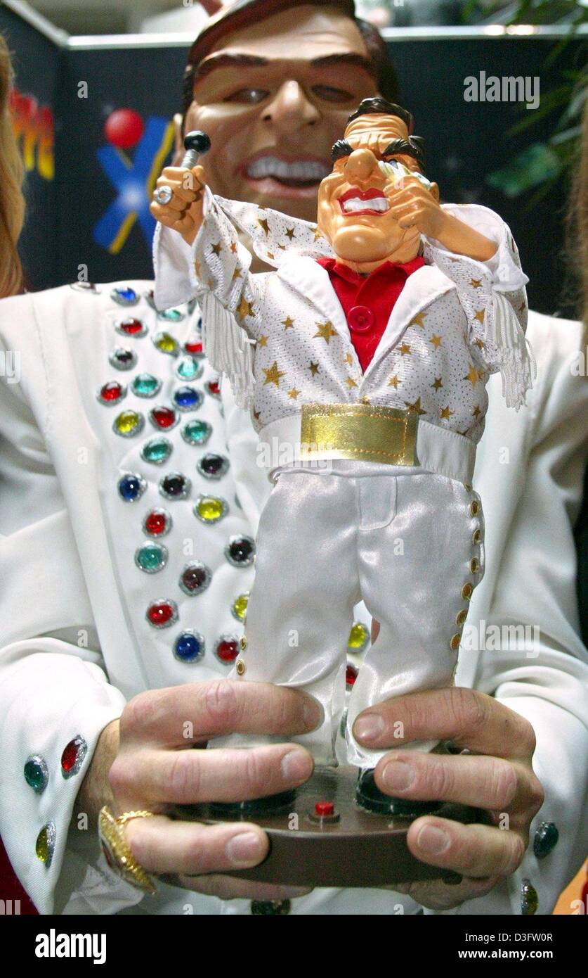 (Dpa) - eine Darsteller eine Kanzlerin Puppe in seinen Händen hält auf der 54. Nürnberger Spielzeug-Messe in Nürnberg, 29. Januar 2003. Die Puppe tanzt im Rhythmus der "Steuersong" (Steuer Song) die verspottet die Steuerpolitik des Bundeskanzlers und war ein großer Hit in den deutschen Charts. Die Chor-Linie geht: 'Ich Greif' Euch Tief in Die Tasche/Jeder von Euch Spackos Bunkert ich Stockfoto (Dpa) - eine Darsteller eine Kanzlerin Puppe in seinen Händen hält auf der 54. Nürnberger Spielzeug-Messe in Nürnberg, 29. Januar 2003. Die Puppe tanzt im Rhythmus der "Steuersong" (Steuer Song) die verspottet die Steuerpolitik des Bundeskanzlers und war ein großer Hit in den deutschen Charts. Die Chor-Linie geht: 'Ich Greif' Euch Tief in Die Tasche/Jeder von Euch Spackos Bunkert ich Stockfoto