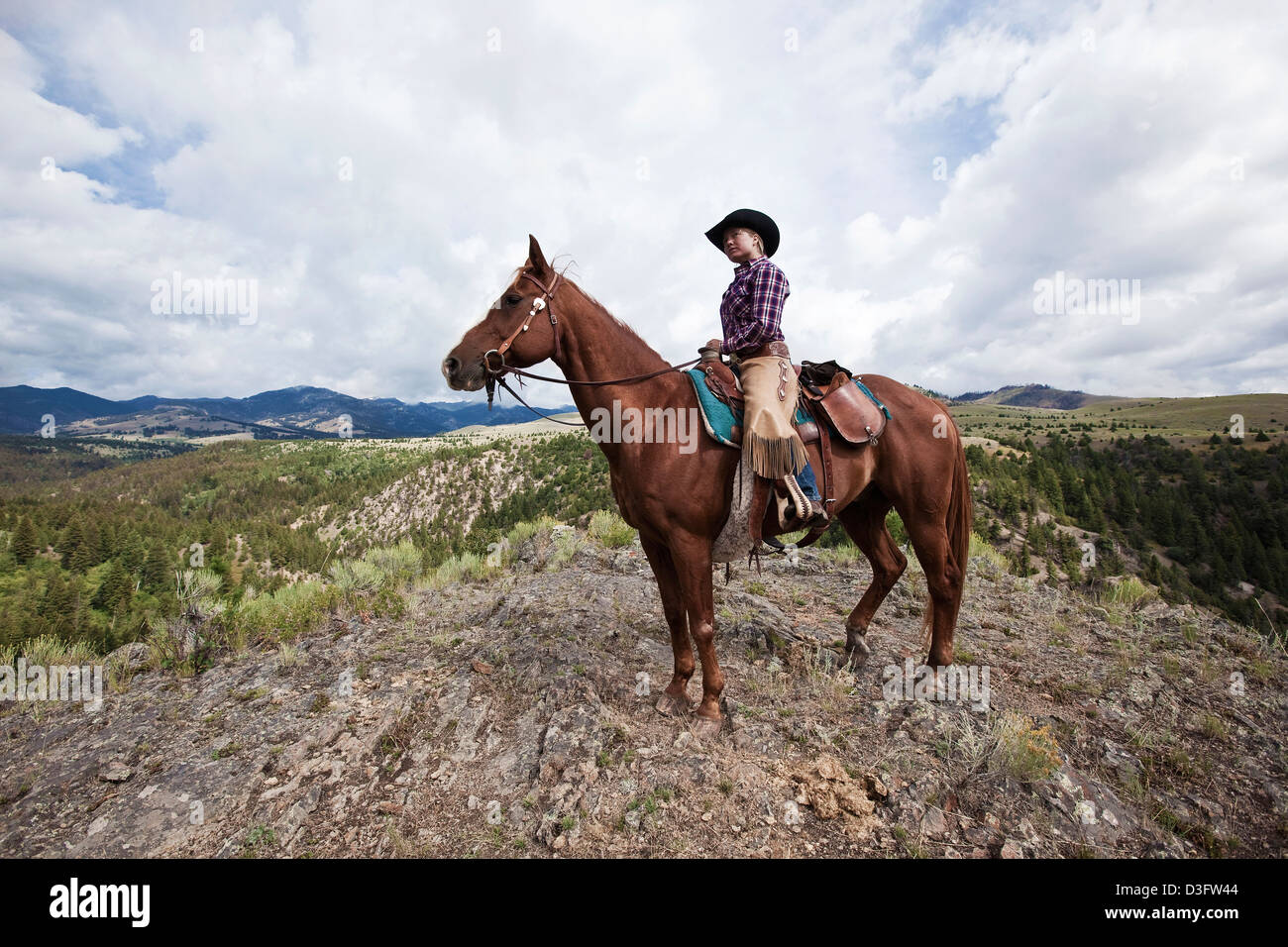 Cowgirl Wrangler auf dem Pferderücken auf Schafe Rock, Montana, USA Stockfoto