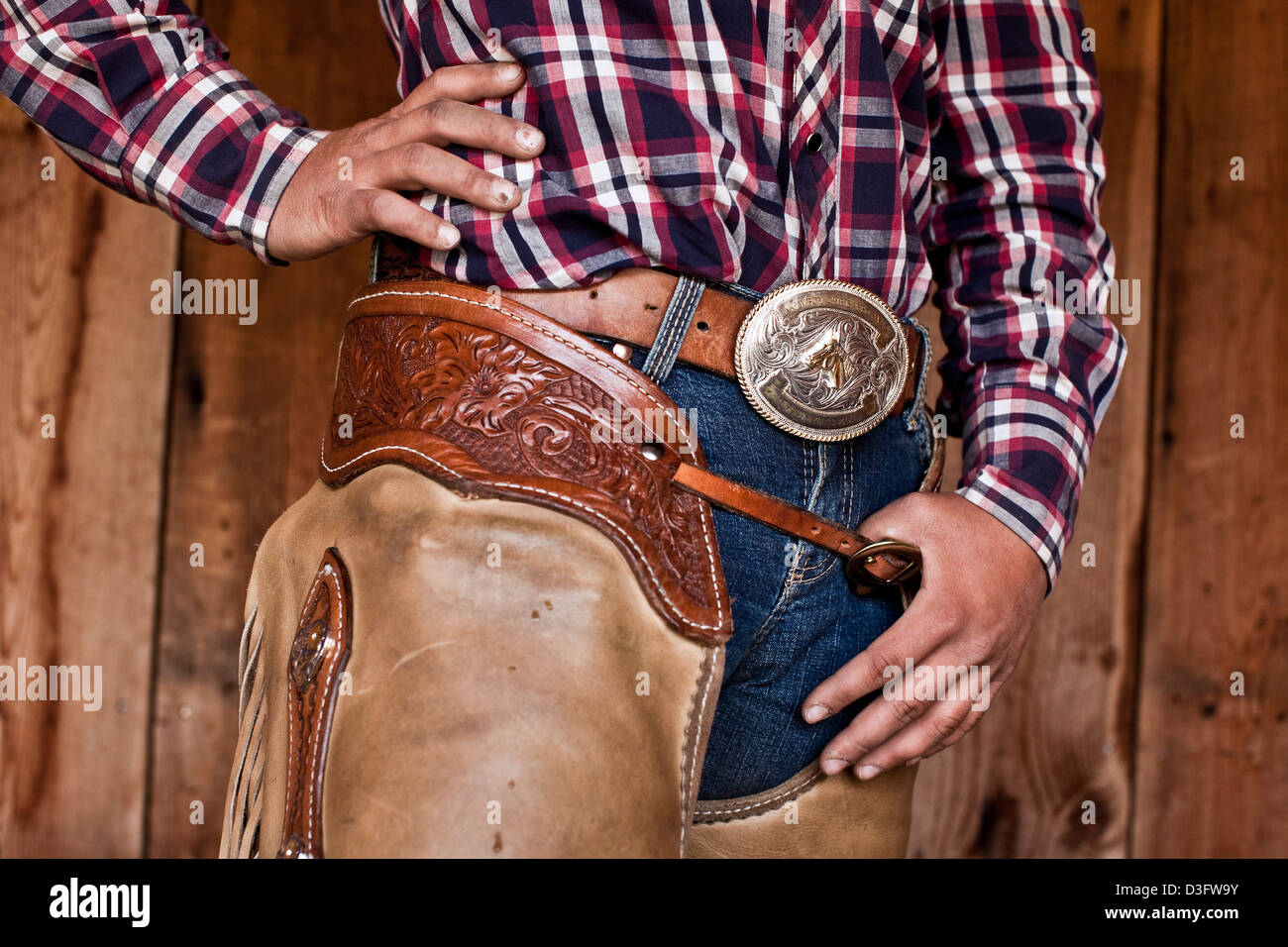 Cowgirl Wrangler stehend mit Daumen im Gürtel Leder Chaps, Montana, USA Stockfoto