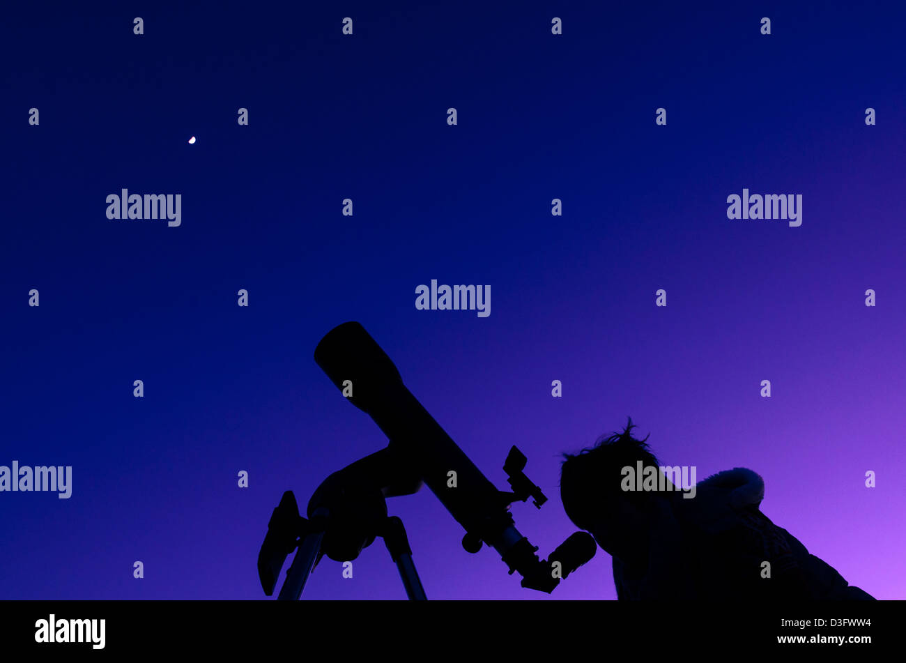 Die Silhouette eines Mädchens in der Dämmerung mit dem Mond-Overhead mit einem Teleskop beobachten. Stockfoto