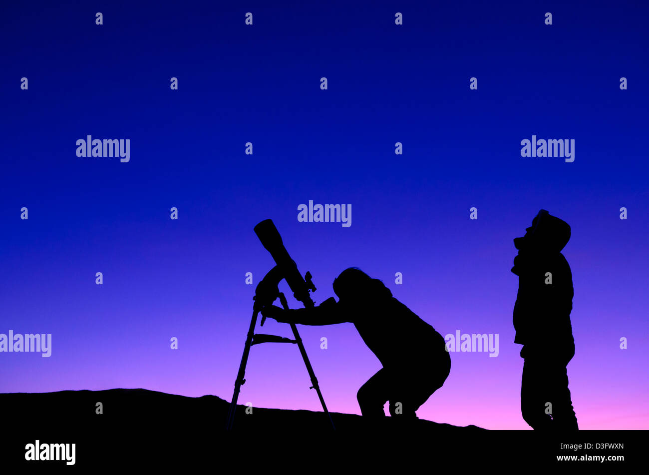 Die Silhouette von zwei Menschen, die mit einem Teleskop in der Abenddämmerung Sternbeobachtung Stockfoto