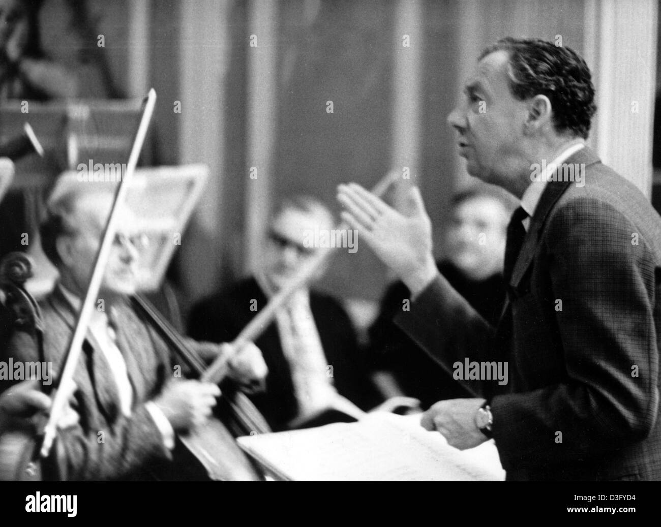 (Dpa-Dateien) - beschreibt, britischer Komponist Benjamin Britten (R) während einer Probe mit dem Kammerorchester der ostdeutschen Staatsoper für die Leistung "War Requiem" in Ost-Berlin, DDR, 5. Januar 1968. Er studierte Klavier bei Harold Samuel und Komposition bei Frank Bridge. Er erhielt ein Stipendium an der Royal College of Music, wo er Unde arbeitete Stockfoto
