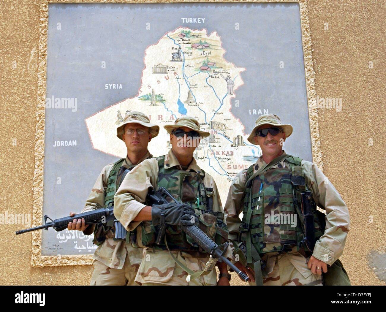 (Dpa) - an ihrem Tag von US Soldaten posieren vor einer Karte des Irak mit seinen Nachbarländern, in Babylon, Irak, 27. April 2003. Die US-Raketen hatten die antiken Ruinen von Babylon südlich von Bagdad verschont. Keine einzige Granate getroffen die Überreste der Gebäude von König Hammurabi oder König Nebuchadnezzar II während des Krieges, aber Archäologen noch fürchten, dass die historischen Stätten der f Stockfoto